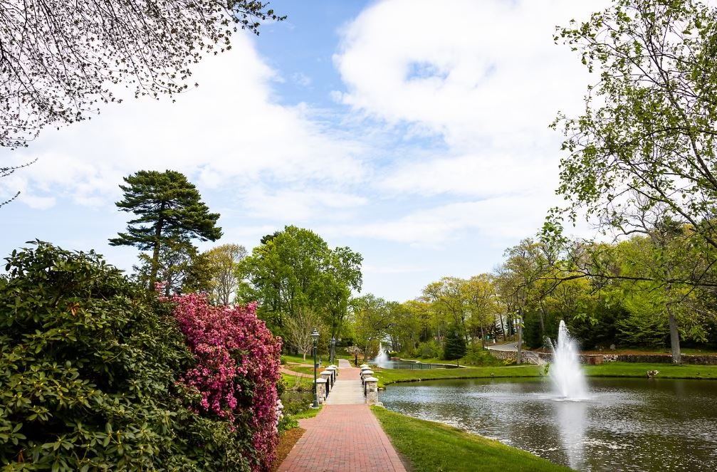 The Endicott College campus in spring, with the pond and footbridge
